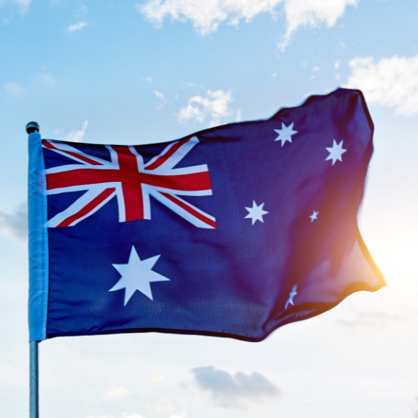 Australian flag blowing in the wind in front of a blue sky